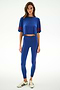 Woman against a white background wears the Djuna Oversized Crop Jersey Tee - Cobalt/Terracotta by SPLITS59, paired with matching leggings and white sneakers with black stripes.