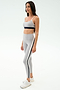 A woman models the SPLITS59 Emerson Airweight High Waist leggings in Dove Grey/Indigo with white sneakers and a light gray sports bra, showcasing a sculpted look ideal for hot yoga against a plain white backdrop.