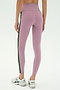 A person wearing SPLITS59 Margot Rigor Legging in mauve with a dark green side stripe and white New Balance sneakers, shown from the back against a plain background.
