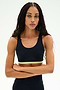 A woman with long braided hair stands with her arms crossed against a plain light background, wearing the SPLITS59 Maci Airweight Bra in Indigo/Limeade, made from stretchy nylon-spandex activewear fabric.