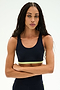 A woman with long braided hair stands with her arms crossed against a plain light background, wearing the SPLITS59 Maci Airweight Bra in Indigo/Limeade, made from stretchy nylon-spandex activewear fabric.
