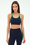A woman stands against a light background wearing the SPLITS59 Robbie Airweight Bra in Indigo/Spearmint, looking directly at the camera.