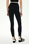Model wearing the SPLITS59 River Dual Waist Airweight Stirrup - Black/Creme leggings with foot straps, crafted from stretch material, paired with black athletic shoes. Shown from the back against a plain white background.