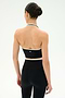 A person with dark hair in a bun is shown from the back, standing against a plain white background, wearing the SPLITS59 Rory Airweight Halter Bralette in Black/Creme paired with high-waisted spandex leggings.