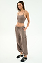 A woman stands in a studio, hands in pockets, wearing SPLITS59’s Nico Airweight Cargo Pant in Lentil with a taupe crop top and black sneakers, perfect for lightweight comfort, facing slightly to the right.