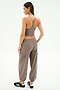 A woman faces away, wearing SPLITS59's Nico Airweight Cargo Pant in Lentil and a taupe sports bra with black Adidas sneakers against a white background—an ideal look for your next workout.
