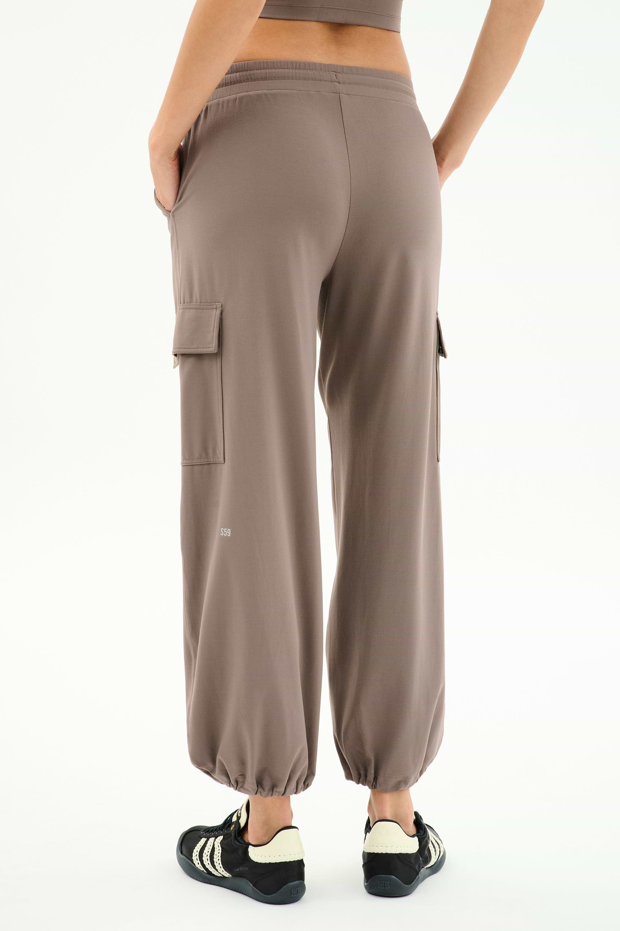 Person wearing SPLITS59 Nico Airweight Cargo Pant in Lentil and black sneakers, shown from the back against a white background—a lightweight, versatile option ideal for workouts.