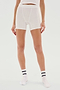 Person wearing white, mid-thigh Theo Rib Short - White from SPLITS59, a white top, and white socks with black stripes, standing against a plain white background. A perfect blend of tailored comfort and classic design.