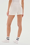 A person wearing SPLITS59 Theo Rib Short - White, a white top, and white socks stands facing away from the camera against a plain background.