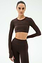 A person wears the SPLITS59 Amelia Airweight Lite Shrug in Dark Chocolate, styled with high-waisted leggings, perfect for yoga or dance, against a plain light background.