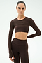 A person wears the SPLITS59 Amelia Airweight Lite Shrug in Dark Chocolate, styled with high-waisted leggings, perfect for yoga or dance, against a plain light background.