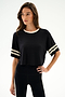 Model wears the SPLITS59 Djuna Oversized Crop Jersey Tee - Black/Creme with matching black leggings, standing against a plain white background.