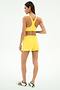 A woman stands facing away, wearing SPLITS59 Ella Airweight Track Short in Bright Yellow/White and a yellow sports bra, paired with white sneakers featuring green stripes.