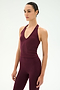 Wearing the SPLITS59 June Rib Halter in Dark Cherry, crafted from a comfortable modal spandex blend, the person stands against a plain white background.