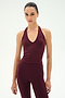 A person stands facing forward wearing the SPLITS59 June Rib Halter in Dark Cherry, a sleeveless top made from a soft modal spandex blend, set against a plain white background.