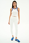 A woman faces forward in the SPLITS59 Kiki Rib Crop Tank - White/Cobalt, featuring sleeveless baby rib fabric with blue trim, paired with white leggings and blue athletic shoes, ideal for gym workouts on a plain white background.