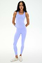 A woman wears the SPLITS59 Mel Airweight Lite Tank in Purple Haze with matching leggings and white sneakers, standing against a plain white background.