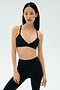 Woman stands against a plain background, wearing the SPLITS59 Theo Rigor Bra - Black and high-waisted black leggings, both crafted from ultra luxe Rigor fabric for multi-sport performance.