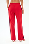 A person wearing SPLITS59 Maxie Rigor Track Pant in Pirate Red/Indigo, with wide legs and navy side stripes, styled with red sandals, stands back to the camera against a plain white background. Crafted from premium Rigor fabric for comfort.