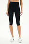 A person wearing SPLITS59 Ella High Waist Airweight Capri in Black/White with white sneakers, standing against a plain background.