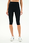 A person wearing SPLITS59 Ella High Waist Airweight Capri in Black/White with white sneakers, standing against a plain background.