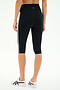 Model wears SPLITS59 Ella High Waist Airweight Capri in Black/White, featuring white side stripes, paired with white sneakers. Shown from the back against a plain background—sleek style and comfort for any workout.