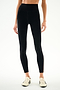 Person wearing SPLITS59 Emerson Airweight High Waist 7/8 - Black/Creme leggings with white sneakers, standing against a plain background.