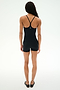 A person faces away from the camera wearing the SPLITS59 Airweight 3.5" Short Jumpsuit in black and black shoes, set against a plain white background.