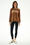 Woman stands against a white background, wearing an Andie Oversized Fleece Varsity Stripe Sweatshirt - Toffee/Splits59 Los Angeles by SPLITS59, black striped leggings, and white Adidas sneakers.