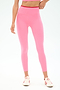 A person wears SPLITS59 Easton Rigor High Waist 7/8 leggings in Strawberry/Pirate Red, paired with a pink crop top and white sneakers with red stripes, standing against a plain white background.