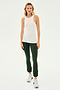A woman stands facing forward wearing the Kiki Rib Tank Full Length in White by SPLITS59, dark green leggings, and gray athletic shoes against a plain white background, ready for yoga or gym workouts.