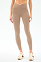 Someone wearing SPLITS59 Mia Rigor Legging w/ Stripe in Latte/White and cream athletic shoes stands against a plain white background.