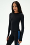 A woman with long braided hair models the SPLITS59 Airweight Lite Long Sleeve Waist Length top in black, paired with black leggings featuring blue side stripes. The fitted, quick-dry, and lightweight workout tee is perfect for gym sessions. She stands confidently against a plain white background.