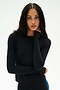 A woman with long braided hair wears the SPLITS59 Airweight Lite Long Sleeve Waist Length top in black, paired with matching black pants, as she stands against a white background and rests one hand on her neck. This fitted top is perfect for gym workouts, offering both comfort and style for every session.