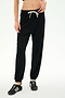 Wearing the SPLITS59 Andie Oversized Fleece Sweatpant in Black, paired with a black top and black sneakers—ideal for cool weather workouts—the individual stands against a plain light background.