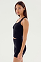 A person with long brown hair wearing the Ashby Rib Crop - Black from SPLITS59 and black shorts, made from baby rib fabric, stands facing slightly to the side against a plain white background. This outfit is perfect for intense gym workouts or casual outings.
