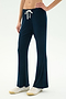 A person wears SPLITS59's Blaire Rib Pant in Indigo, made from soft modal fabric, with white sneakers—pictured waist down against a plain light backdrop.