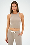 A woman wearing the SPLITS59 Kiki Rib Crop Tank in Latte and matching drawstring pants, made from baby rib fabric, poses against a plain background.