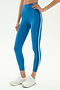 A person wears SPLITS59 Ella High Waist Airweight 7/8 leggings in Stone Blue/Graphite, featuring black and white side stripes—ideal for hot yoga—paired with white athletic shoes, against a plain background.