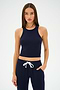 A person wearing the SPLITS59 Kiki Rib Crop Tank in Indigo and matching pants with a white drawstring stands against a plain background, ready for gym workouts.