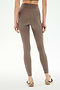 A person wearing SPLITS59 Airweight High Waist 7/8 Pocket Legging in Lentil and sneakers stands facing away against a plain, light background.
