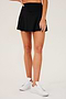 Front view of girl wearing black upper thigh skirt with built in shorts and white shoes