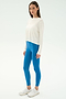A woman wears the SPLITS59 Djuna Long Sleeve in white, styled with bright blue leggings and white athletic shoes—ideal for gym or outdoor workouts—posed against a plain white background.