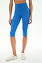 Model wearing SPLITS59 Airweight High Waist 16" Capri Legging in Classic Blue, paired with white athletic shoes, standing against a plain white background.