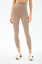 A person wearing SPLITS59 Airweight Super High Waist 7/8 leggings in Latte with cream sneakers, shown midriff to feet against a plain background—ideal for hot yoga thanks to the ultra luxe Airweight fabric.