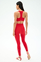 A woman stands facing away, wearing a matching SPLITS59 Sara Airweight Bra in Pirate Red and leggings with white sandals—perfect for hot yoga or Pilates. The background is plain white.