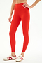 A person wearing SPLITS59 Airweight Rib High Waist 7/8 leggings in Lotus Red and white sneakers with red stripes stands with one hand on their hip.