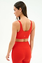 A woman faces away, showcasing the SPLITS59 Airweight Rib Bra in Lotus Red with matching high-waisted leggings, both crafted from moisture-wicking, ribbed Airweight fabric against a plain light background.