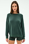 A woman stands facing forward wearing the SPLITS59 Andie Fleece Sweatshirt in Military, paired with matching shorts, both crafted from soft stretch modal fabric, against a plain light background.