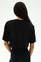 Person with long braided hair wears the SPLITS59 Djuna Oversized Crop Jersey Tee in black, a loose short-sleeve crop top shown from the back against a plain background.